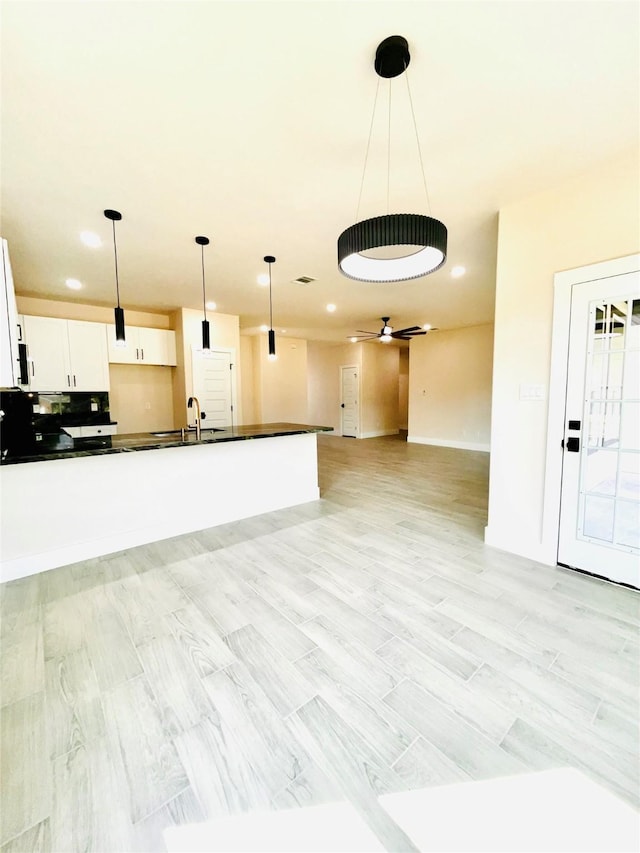 2309 Forest Hill Ln, Granbury, TX 76048 - kitchen featuring dark countertops, a sink, white cabinets, decorative light fixtures, and open floor plan