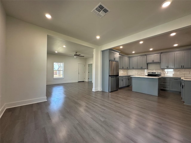 907 Davis St S, Sulphur Springs, TX 75482 - kitchen with gray cabinets, freestanding refrigerator, electric range oven, open floor plan, and backsplash