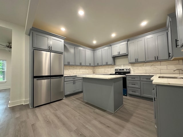 907 Davis St S, Sulphur Springs, TX 75482 - kitchen with appliances with stainless steel finishes, gray cabinets, a sink, wood finished floors, and recessed lighting