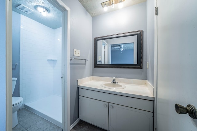 24 W Mountain Creek Dr, Grand Prairie, TX 75052 - full bathroom with toilet, vanity, a textured ceiling, tiled shower, and tile patterned floors