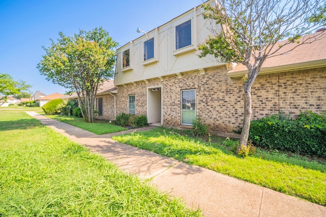 24 W Mountain Creek Dr, Grand Prairie, TX 75052 - view of front of house featuring brick siding, a front yard, and stucco siding