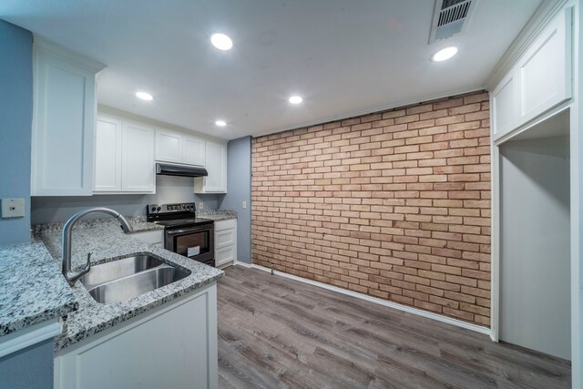24 W Mountain Creek Dr, Grand Prairie, TX 75052 - kitchen featuring range with electric stovetop, brick wall, a sink, under cabinet range hood, and white cabinetry