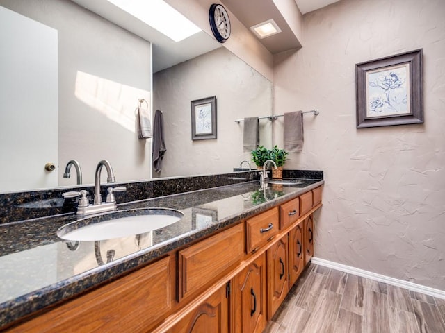 1507 Juniper Ln, Lewisville, TX 75077 - bathroom with wood finished floors, double vanity, and baseboards