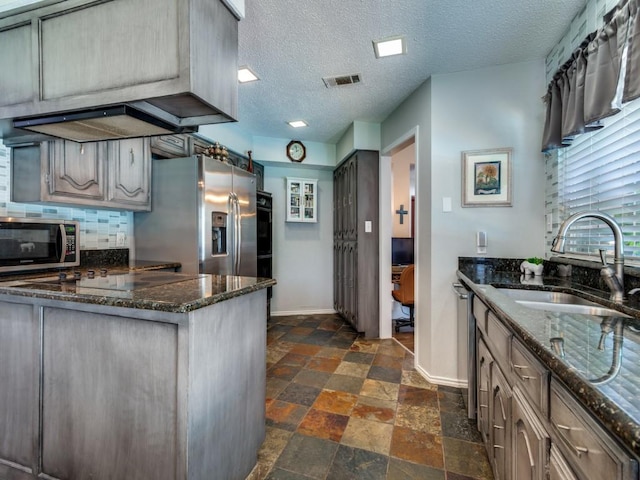 1507 Juniper Ln, Lewisville, TX 75077 - kitchen with stainless steel appliances, a sink, stone tile flooring, baseboards, and a textured ceiling