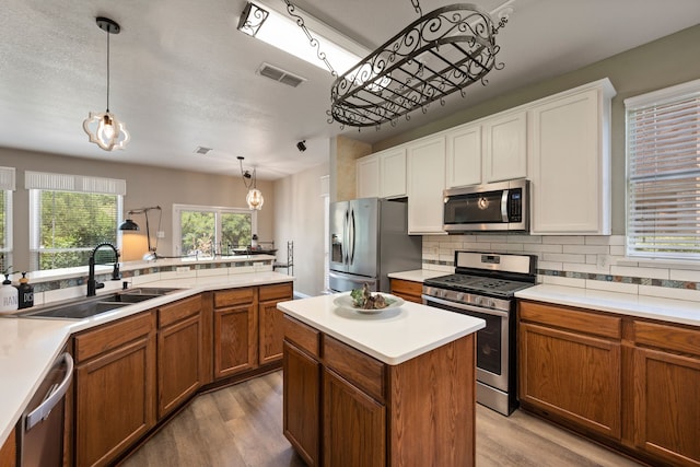 5033 Glenscape Trl, Fort Worth, TX 76137 - kitchen with stainless steel appliances, a sink, light wood-type flooring, and brown cabinetry