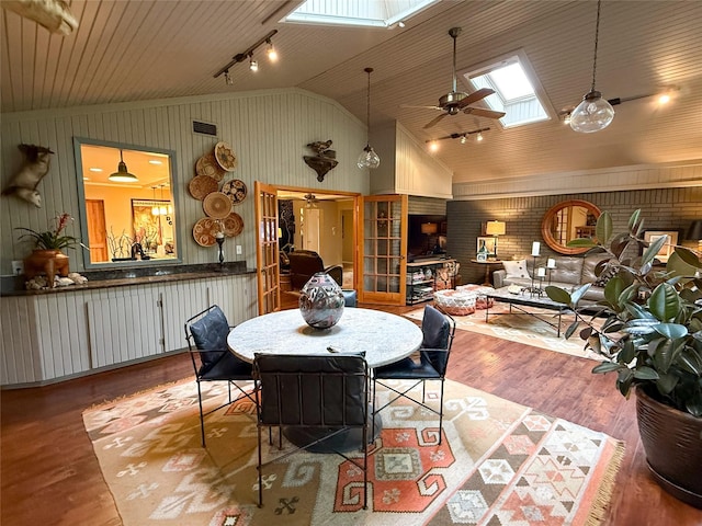 3833 Wilkie Way, Fort Worth, TX 76133 - dining room featuring a skylight, a ceiling fan, wood finished floors, high vaulted ceiling, and wood walls