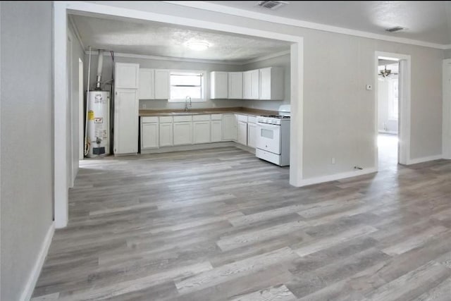 503 SW 15th Ave, Mineral Wells, TX 76067 - kitchen featuring white gas range, ornamental molding, gas water heater, a sink, and white cabinetry