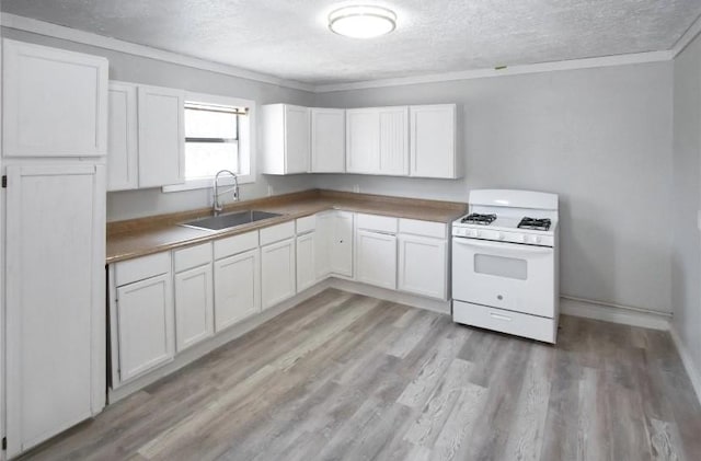 503 SW 15th Ave, Mineral Wells, TX 76067 - kitchen with white range with gas cooktop, a sink, a textured ceiling, ornamental molding, and light wood-type flooring