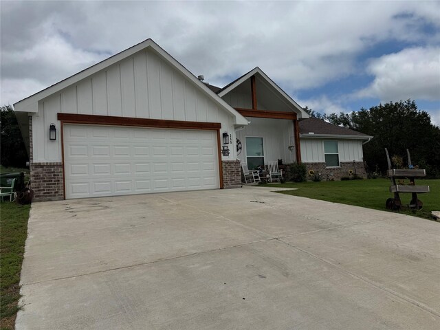355 Sunset Cv, Bluff Dale, TX 76433 - view of front of home featuring brick siding, board and batten siding, concrete driveway, and a front yard