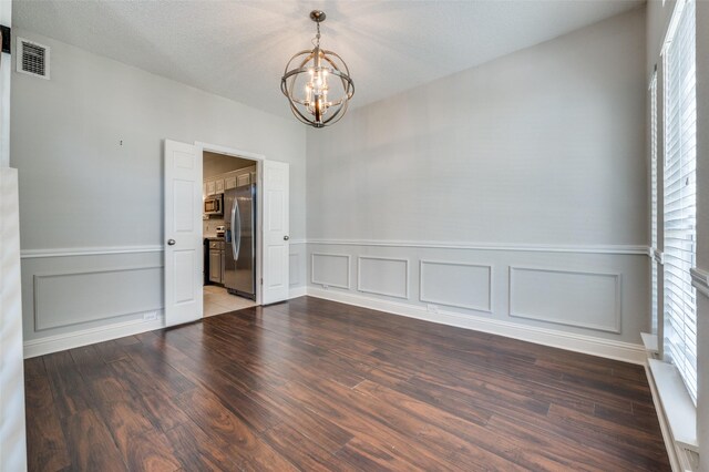 2211 Meadowstone Dr, Carrollton, TX 75006 - unfurnished room featuring a chandelier, wood finished floors, a decorative wall, and a wainscoted wall