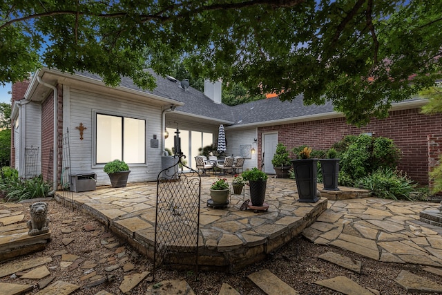 4055 Seabury Dr, Dallas, TX 75287 - rear view of house featuring a patio, brick siding, a chimney, and a shingled roof