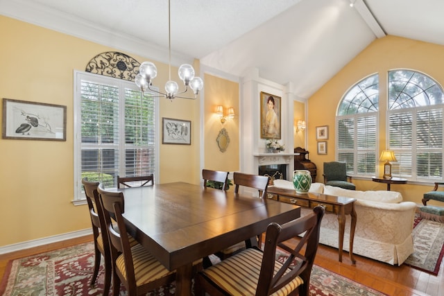 4055 Seabury Dr, Dallas, TX 75287 - dining area with wood finished floors, healthy amount of natural light, a chandelier, a glass covered fireplace, and lofted ceiling