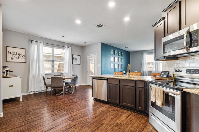 457 Silverstone Dr, Waxahachie, TX 75165 - kitchen with stainless steel appliances, dark brown cabinets, a sink, dark wood-type flooring, and recessed lighting