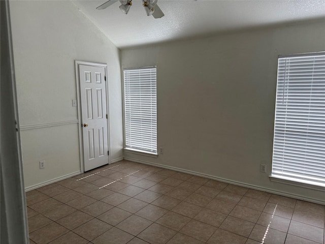 2825 Saint Croix Ave, Lancaster, TX 75134 - empty room with a ceiling fan, tile patterned floors, vaulted ceiling, and baseboards