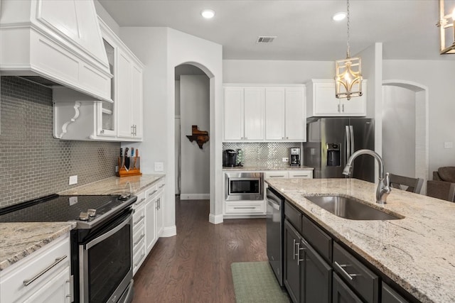 309 Bluffside Trl, Benbrook, TX 76126 - kitchen featuring stainless steel appliances, arched walkways, a sink, custom range hood, and recessed lighting