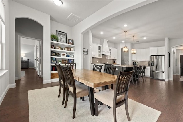 309 Bluffside Trl, Benbrook, TX 76126 - dining area with arched walkways, dark wood finished floors, baseboards, and recessed lighting