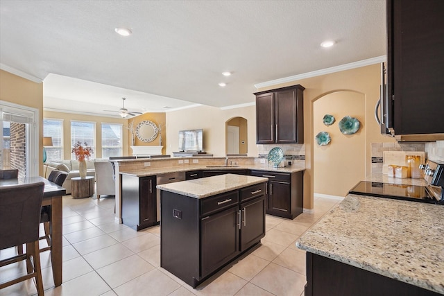 200 Baldwin Dr, Fate, TX 75189 - kitchen with range, arched walkways, a peninsula, a sink, and tasteful backsplash