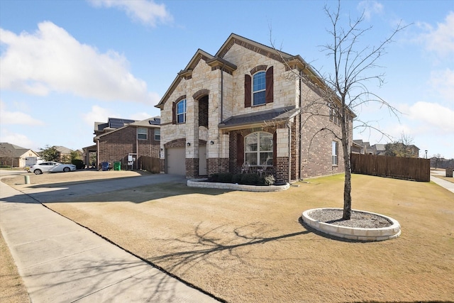 200 Baldwin Dr, Fate, TX 75189 - french country home with concrete driveway, a garage, brick siding, and stone siding