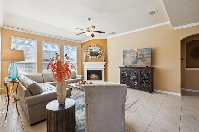 200 Baldwin Dr, Fate, TX 75189 - living area with a ceiling fan, crown molding, light tile patterned floors, a warm lit fireplace, and baseboards