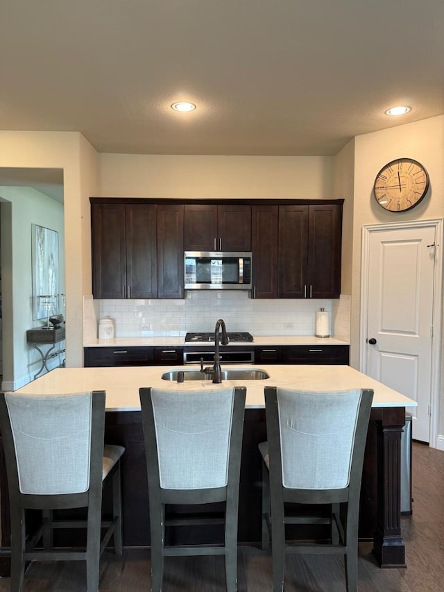 1301 Cold Stream Dr, Wylie, TX 75098 - kitchen featuring stainless steel microwave, a sink, decorative backsplash, light countertops, and recessed lighting