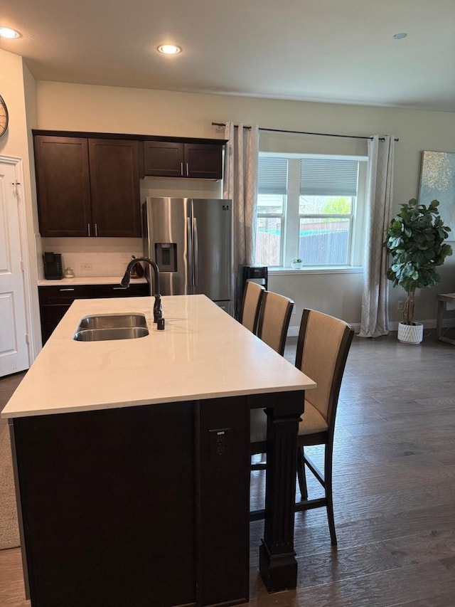 1301 Cold Stream Dr, Wylie, TX 75098 - kitchen with stainless steel fridge, a sink, dark brown cabinetry, light countertops, and a center island with sink