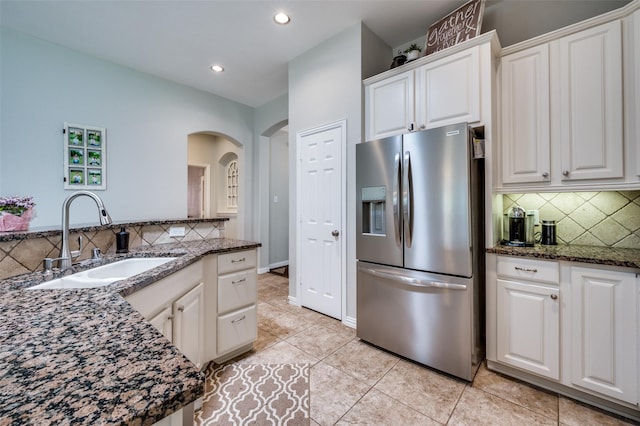 3526 Washington Dr, Frisco, TX 75034 - kitchen with stainless steel fridge, a sink, tasteful backsplash, arched walkways, and white cabinetry