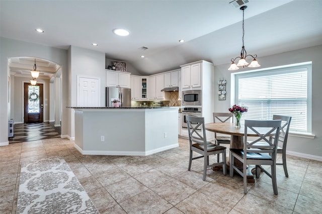 3526 Washington Dr, Frisco, TX 75034 - kitchen with appliances with stainless steel finishes, arched walkways, white cabinetry, decorative backsplash, and light tile patterned floors