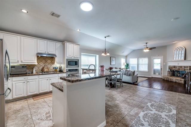 3526 Washington Dr, Frisco, TX 75034 - kitchen with stainless steel appliances, under cabinet range hood, vaulted ceiling, backsplash, and ceiling fan