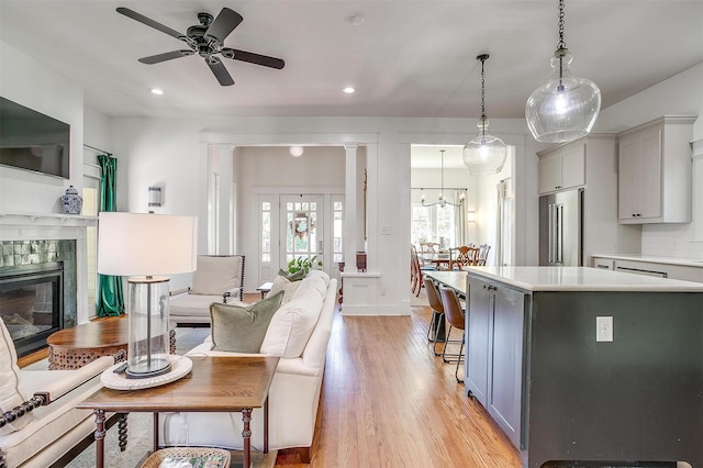 2913 Willing Ave, Fort Worth, TX 76110 - kitchen with high quality fridge, gray cabinetry, light countertops, a tiled fireplace, and recessed lighting