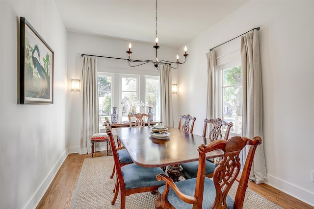 2913 Willing Ave, Fort Worth, TX 76110 - dining area featuring a chandelier, light wood-style floors, and baseboards