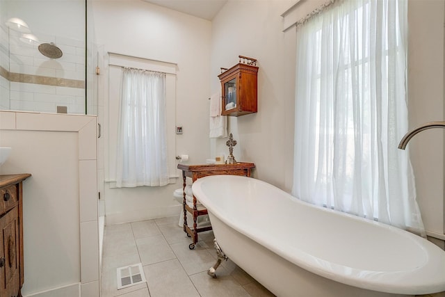 2913 Willing Ave, Fort Worth, TX 76110 - bathroom featuring a soaking tub, tile patterned flooring, tiled shower, vanity, and baseboards