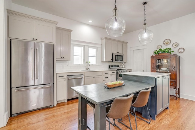 2913 Willing Ave, Fort Worth, TX 76110 - kitchen with stainless steel appliances, a sink, light wood finished floors, a kitchen island, and light countertops