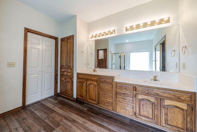 4404 Bentley Dr, Plano, TX 75093 - full bath featuring double vanity, wood finished floors, a textured ceiling, and an enclosed shower