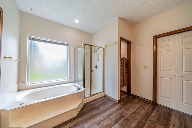 4404 Bentley Dr, Plano, TX 75093 - full bathroom featuring a stall shower, a garden tub, wood finished floors, a textured ceiling, and a closet