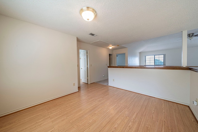 4404 Bentley Dr, Plano, TX 75093 - spare room with light wood-style flooring, a textured ceiling, baseboards, and attic access
