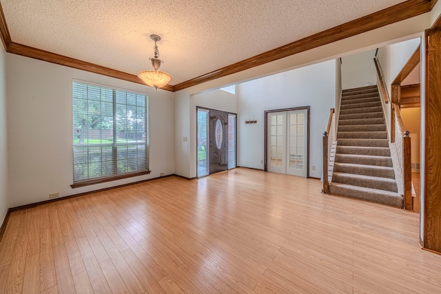 4404 Bentley Dr, Plano, TX 75093 - unfurnished room with crown molding, a textured ceiling, stairway, and light wood-style flooring