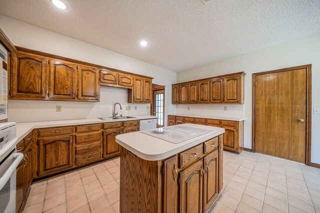4404 Bentley Dr, Plano, TX 75093 - kitchen with white appliances, a sink, brown cabinetry, light countertops, and a textured ceiling