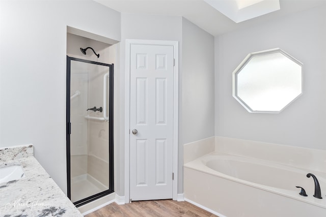 9756 Amblewood Ln, Shreveport, LA 71118 - bathroom with a stall shower, a bath, wood finished floors, and vanity