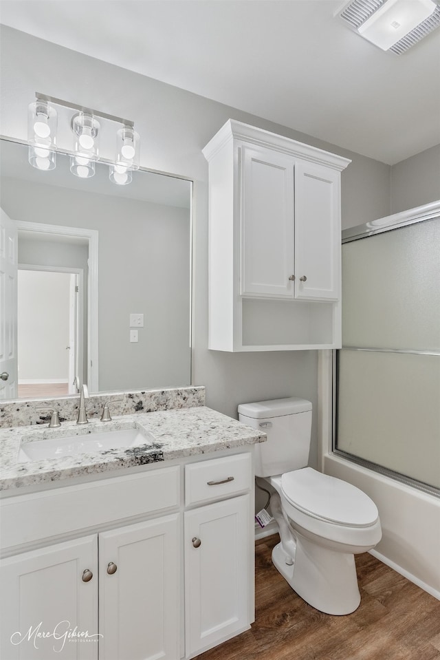 9756 Amblewood Ln, Shreveport, LA 71118 - bathroom with wood finished floors, vanity, toilet, and bath / shower combo with glass door