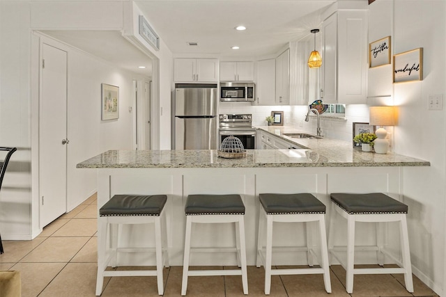 104 Kingsway, Tool, TX 75143 - kitchen with appliances with stainless steel finishes, a sink, a peninsula, white cabinets, and tasteful backsplash