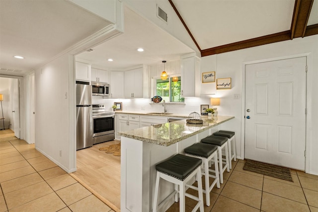 104 Kingsway, Tool, TX 75143 - kitchen with appliances with stainless steel finishes, a peninsula, a sink, white cabinets, and light stone countertops