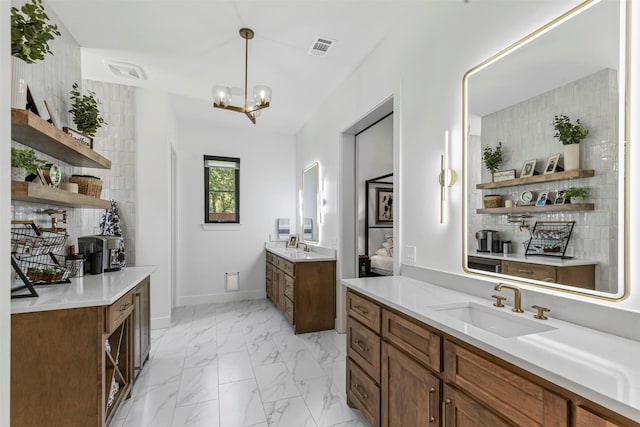 7799 Barber Ranch Rd, Fort Worth, TX 76126 - bathroom with two vanities, marble finish flooring, a chandelier, and baseboards