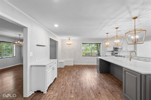 1226 Manor Pl, Shreveport, LA 71118 - kitchen with a chandelier, appliances with stainless steel finishes, white cabinets, and ornamental molding
