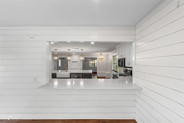1226 Manor Pl, Shreveport, LA 71118 - kitchen with stainless steel appliances, a peninsula, a chandelier, crown molding, and a sink