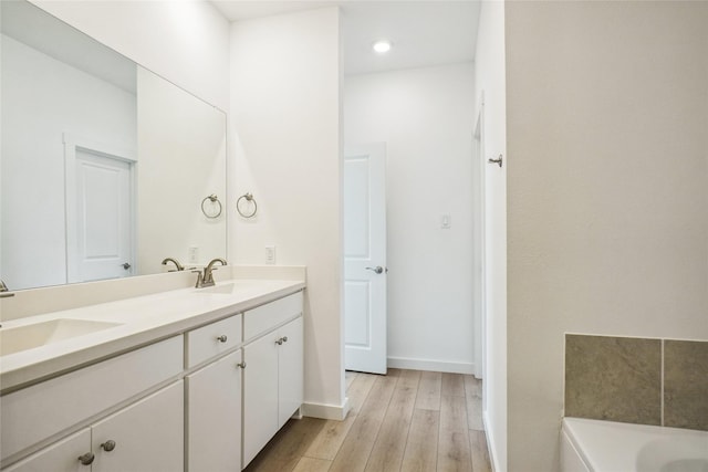 3811 Rosemont Dr, Prosper, TX 75078 - full bath featuring double vanity, wood finished floors, a bath, baseboards, and recessed lighting
