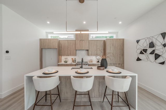 5320 Reiger Ave Unit 101, Dallas, TX 75214 - kitchen featuring a sink, light countertops, a kitchen breakfast bar, modern cabinets, and recessed lighting