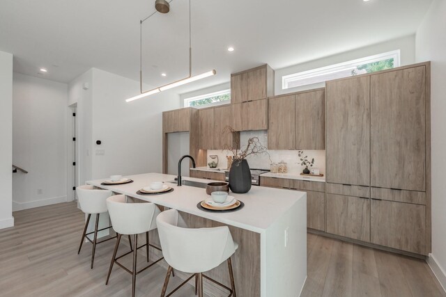 5320 Reiger Ave Unit 101, Dallas, TX 75214 - kitchen featuring a breakfast bar area, a center island with sink, modern cabinets, light countertops, and recessed lighting