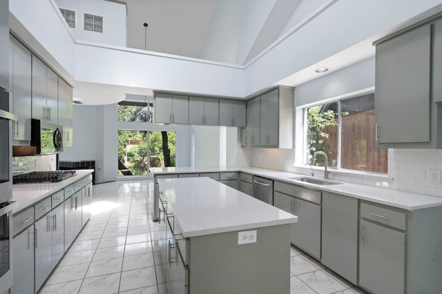 8907 Club Creek Cir, Dallas, TX 75238 - kitchen with light marble finish flooring, gray cabinetry, a center island, decorative backsplash, and high vaulted ceiling