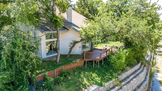 8907 Club Creek Cir, Dallas, TX 75238 - view of side of property with brick siding, a wooden deck, a chimney, and a shingled roof