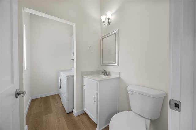 120 Hollie Dr, Red Oak, TX 75154 - bathroom featuring washer and dryer, wood finished floors, vanity, toilet, and baseboards